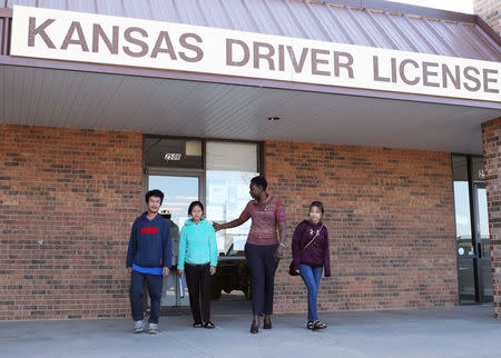 Amy Longa (2nd R) and Hlu You Esther (R) lead Wimber Htoo (L) and Htoo Lwae Say from the Kansas Driver License building as they start the process of getting their new IDs in Garden City, Kansas, U.S., March 28, 2018. Picture taken March 28, 2018. REUTERS/Adam Shrimplin