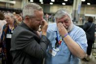 CORRECTS ID: Rev. Andy Oliver, Pastor of Allendale UMC in St. Petersburg, Florida, left, and David Meredith wipe away tears after an approval vote at the United Methodist Church General Conference Wednesday, May 1, 2024, in Charlotte, N.C. United Methodist delegates repealed their church’s longstanding ban on LGBTQ clergy with no debate on Wednesday, removing a rule forbidding “self-avowed practicing homosexuals” from being ordained or appointed as ministers. (AP Photo/Chris Carlson)
