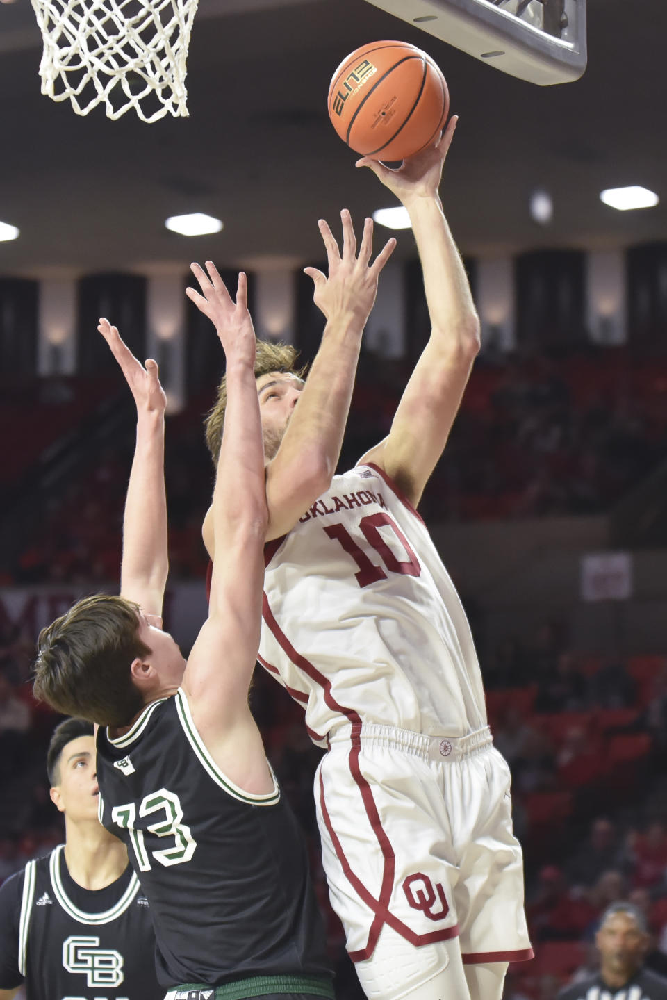 Oklahoma forward Sam Godwin (10) goes up for a shot over Green Bay forward Marcus Hall (13) during the first half of an NCAA college basketball game Saturday, Dec. 16, 2023, in Norman, Okla. (AP Photo/Kyle Phillips)