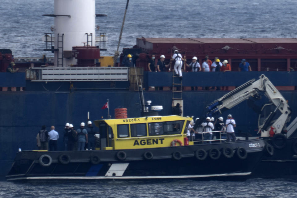 Russian, Ukrainian, Turkish and U.N. officials arrive to the cargo ship Razoni for inspection while it is anchored at the entrance of the Bosphorus Strait in Istanbul, Turkey, Wednesday, Aug. 3, 2022. The Sierra Leone-flagged Razoni, loaded up with 26,000 tons of corn, is the first cargo ship to leave Ukraine since the Russian invasion, and set sail from Odesa Monday, August 1, 2022. Its final destination is Lebanon. (AP Photo/Khalil Hamra)