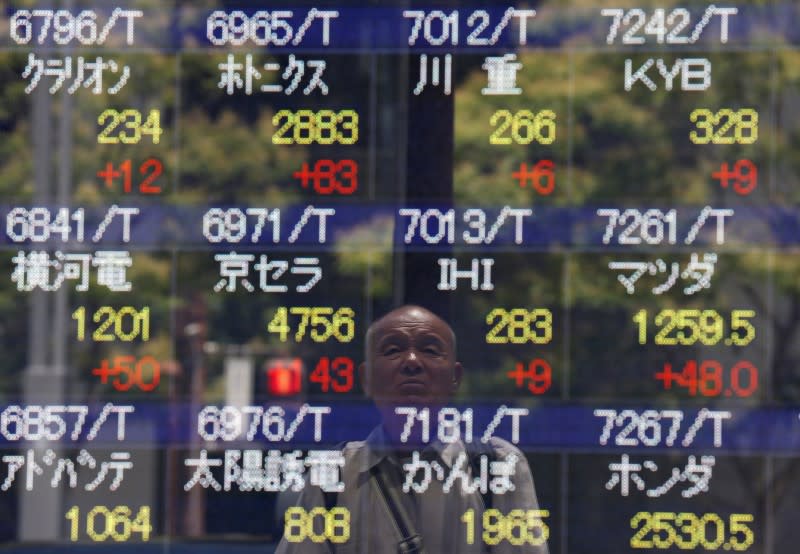 A man is reflected on a stock quotation board outside a brokerage in Tokyo, Japan July 11, 2016. REUTERS/Issei Kato