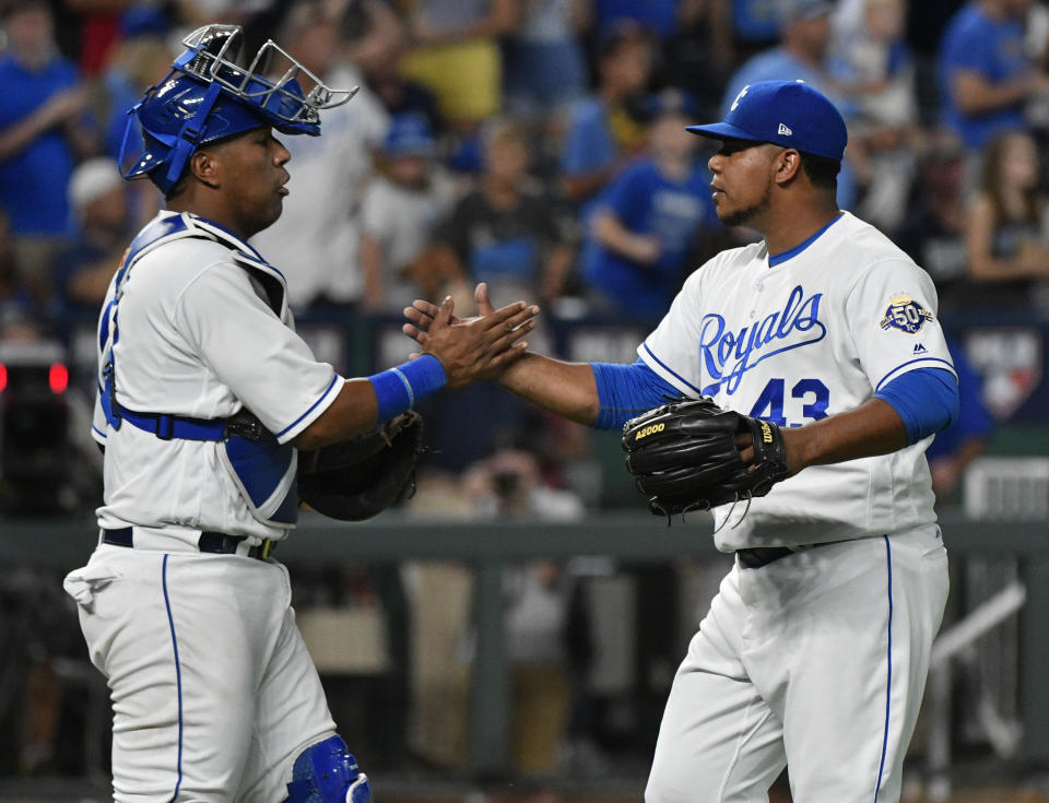 Kansas City Royals catcher Salvador Perez (13) and relief pitcher Wily Peralta (43) celebrate the team's 5-4 win over the Detroit Tigers in a baseball game Tuesday, July 24, 2018, in Kansas City, Mo. (AP Photo/Ed Zurga)