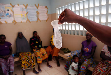 A nurse from Marie Stopes NGO displays a condom during a family planning course at a dispensary in the village of Nedgo, near Ouagadougou, Burkina Faso February 16, 2018. REUTERS/Luc Gnago