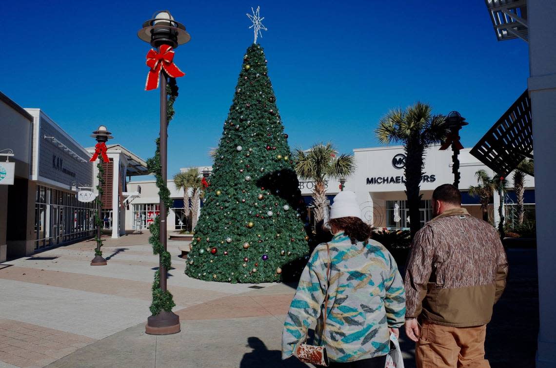 Shoppers brave gusty winds and falling temperatures to fulfill their holiday wish lists at Tanger Outlets near Myrtle Beach, S.C. Dec. 23, 2022.