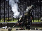 Government soldiers of Task Force Zamboanga (TFZ) fire a 60mm mortar round towards the Muslim rebels of Moro National Liberation Front (MNLF) positions in Zamboanga city in southern Philippines September 16, 2013. (REUTERS/Erik De Castro)