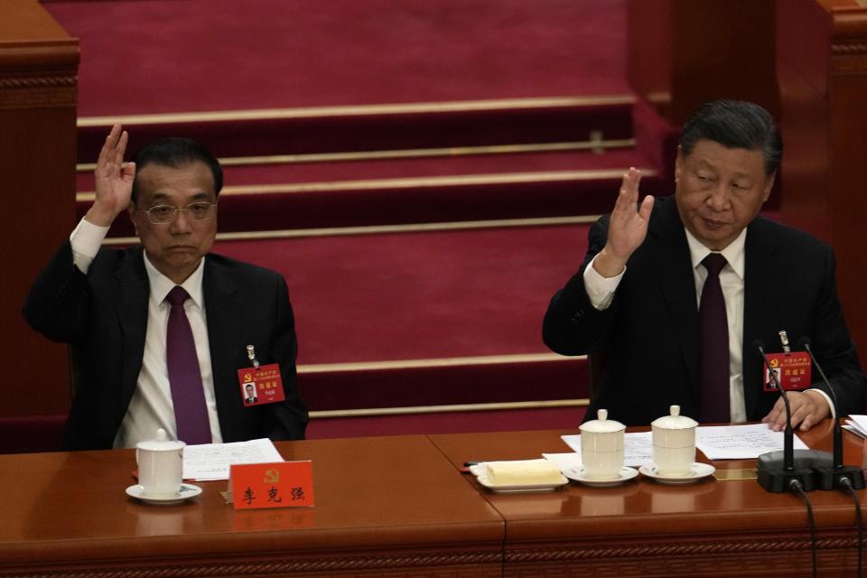 Chinese President Xi Jinping looks over as Chinese Premier Li Keqiang raises his hand to vote at the closing ceremony of the 20th National Congress of China's ruling Communist Party at the Great Hall of the People in Beijing, Saturday, Oct. 22, 2022. Chinese Premier Li Keqiang, the nation's No. 2 official and a chief proponent of economic reforms, is among four of the seven members of the nation's all-powerful Politburo Standing Committee who will not be reappointed in a leadership shuffle Sunday. (AP Photo/Ng Han Guan)