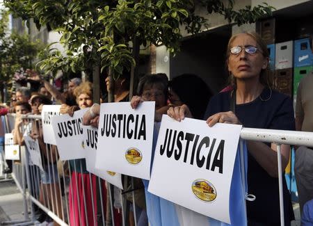 People hold signs that read "Justice" outside the AMIA Jewish community center during a demonstration to demand justice over the death of Argentine prosecutor Alberto Nisman in Buenos Aires January 21, 2015. REUTERS/Enrique Marcarian