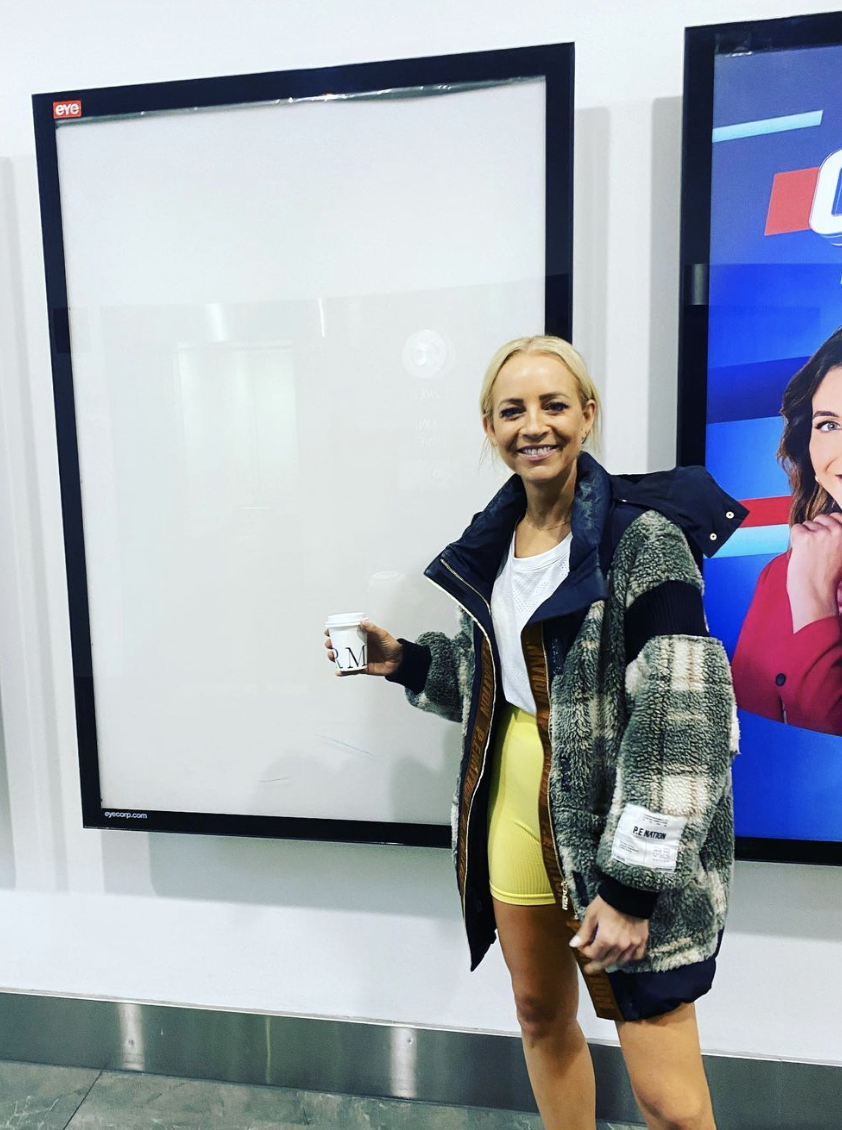 Carrie Bickmore poses in activewear next to an empty frame. 