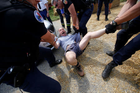 Cycling - Tour de France - The 218-km Stage 16 from Carcassonne to Bagneres-de-Luchon - July 24, 2018 - Police officers carry a protester off the road. REUTERS/Stephane Mahe