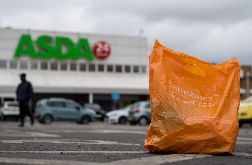 In this arranged photo illustration, a Sainsbury’s shopping bag is seen on the ground in the car park of an Asda supermarket on April 29, 2018 in London, England.Photo: Chris J Ratcliffe/Getty Images