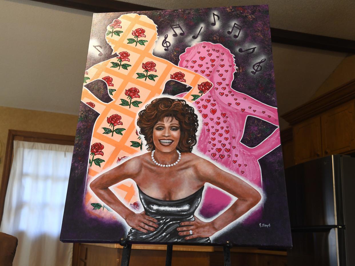 Raymond Floyd was a Spartanburg artist and art teacher. He was the first Black art educator in Spartanburg District 7. He passed away Nov. 21 at 82. Heather Mitchell shows off one of her father's paintings of famous people, this one is of Whitney Houston.