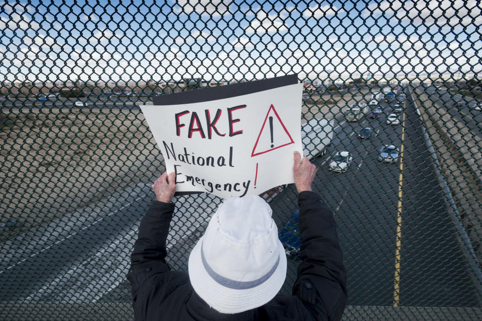 Al Close flashes a sign over Interstate 15 in Victorville, Calif., Monday, Feb. 18, 2019, during a protest against President Donald Trump's declaration of national emergency to build a southern border wall. (James Quigg/The Daily Press via AP)