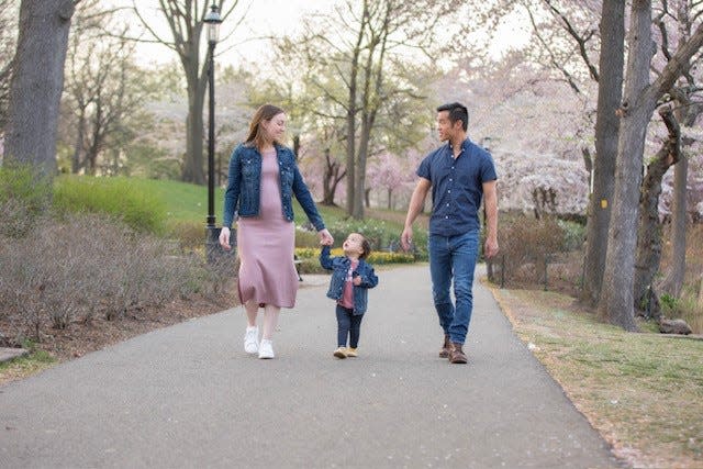 Jaclyn Lin walking with her oldest daugter and husband while she was pregnant.