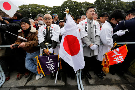 Well-wishers hold Japanese national flags before appearance of Japan's Emperor Akihito (not pictured) at the Imperial Palace to celebrate the emperor's 85th birthday in Tokyo, Japan, December 23, 2018. REUTERS/Issei Kato