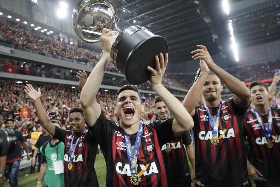 Raphael Veiga of Brazil's Atletico Paranaense celebrates with the trophy after defeating Colombia's Junior at the Copa Sudamericana final soccer match in Curitiba, Brazil, Thursday, Dec. 13, 2018. Atletico Paranaense defeated Junior 4-3 with penalties after the match ended 1-1 with extra time. (AP Photo/Andre Penner)