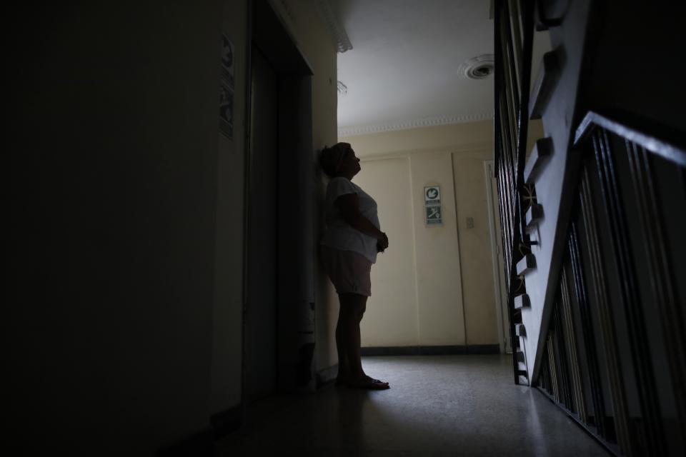 Orelis Lehmann rests from climbing the stairs to her apartment in Caracas, Venezuela, Tuesday, July 23, 2019. With the power outage that began Monday afternoon the elevator is out. (AP Photo/Ariana Cubillos)