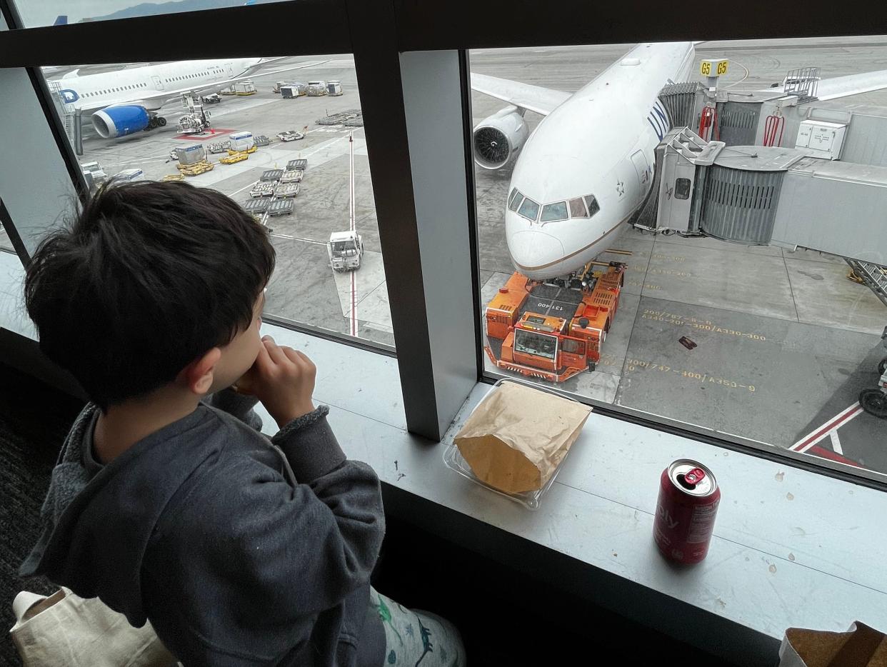 Christy Tending's son looking out the airport window at a plane