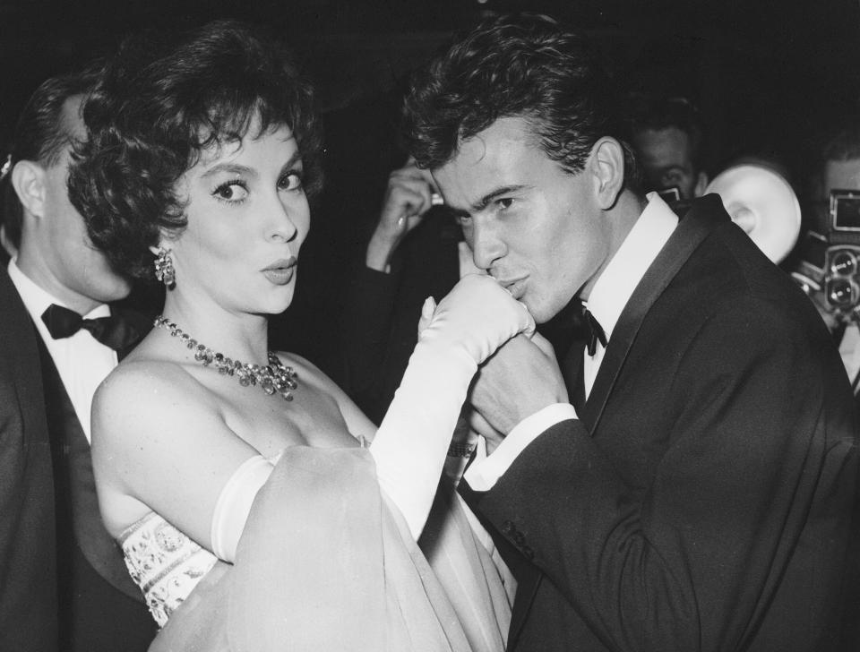 ARCHIVO – El actor alemán Horst Buchholz besa la mano de la actriz italiana Gina Lollobrigida en el Festival Internacional de Cine de Berlín en Berlín, Alemania, el 5 de julio de 1958. La leyenda del cine italiano Gina Lollobrigida, que alcanzó el estrellato cinematográfico internacional durante la década de 1950 y fue apodada “la mujer más bella del mundo” por el título de una de sus películas, murió en Roma el lunes 16 de enero de 2023, dijo su agente. Tenía 95 años (Foto AP/Werner Kreusch, archivo)