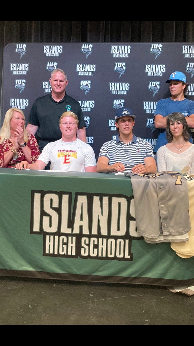 Cooper Bachman, center left, and Mitchell Singletary, center right, of Islands High School at their signing ceremony Friday.