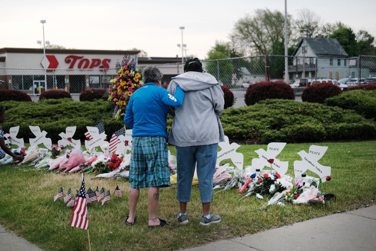 People gather at a memorial for the shooting victims outside of Tops market in Buffalo, New York on May 20, 2022.