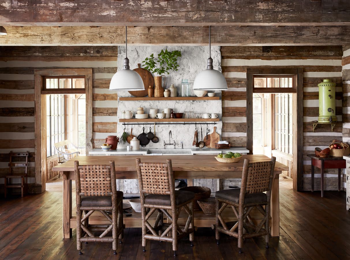 reclaimed wood graces the floor and ceiling and center of the kitchen which features a custom island crafted from antique white oak that is paired with rustic woven back counter stools