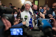 Taliban official Abdul Salam Hanafi, center, speaks to media during talks involving Afghan representatives in Moscow, Russia, Wednesday, Oct. 20, 2021. Russia invited the Taliban and other Afghan parties for talks voicing hope they will help encourage discussions and tackle Afghanistan's challenges. (AP Photo/Alexander Zemlianichenko, Pool)