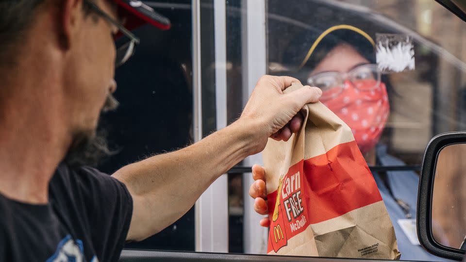 A customer receives his food in a McDonald's drive-thru on July 28, 2021 in Houston, Texas. - Brandon Bell/Getty Images