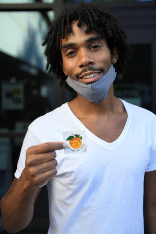 Rashad Muneer, 31, a real estate investor poses for a portrait as he leaves the Gladys S. Dennard Library, on the penultimate day of early voting ahead of Election Day 2020, in Atlanta, South Fulton County