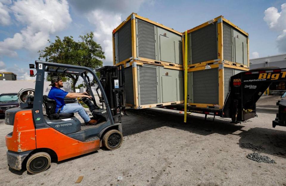 Chris Mejia uses a forklift to move commercial air conditioning units into the Watsco Gemaire warehouse in Doral, on June 30, 2023. Al Diaz/adiaz@miamiherald.com