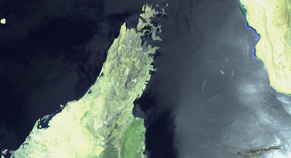 This June 13, 2019 false-color image from the European Commission's Sentinel-2 satellite that was processed by Sinergise's Sentinel Hub website shows the Norwegian-owned MT Front Altair, bottom right, ablaze with smoke rising from it in the Gulf of Oman after what the U.S. described as a limpet mine attack by Iran. Iran has denied being involved in the incident. The land mass to the left is the United Arab Emirates and Oman on the Arabian Peninsula. The land mass in the upper right hand corner is Iran. (European Commission via AP)