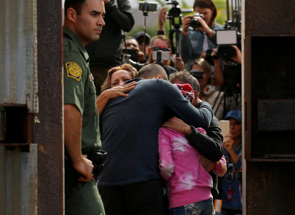 FILE PHOTO - U.S. Border patrol agents stands at an open gate on the fence along the Mexico border to allow Adrian Gonzalez-Morales and his daughter Aileen hug his parents Juan and Martha, as part of Universal Children's Day at the Border Field State Park, California, U.S. on November 19, 2016. REUTERS/Mike Blake/File Photo