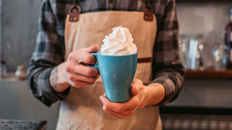 Whipped cream on mug of coffee
