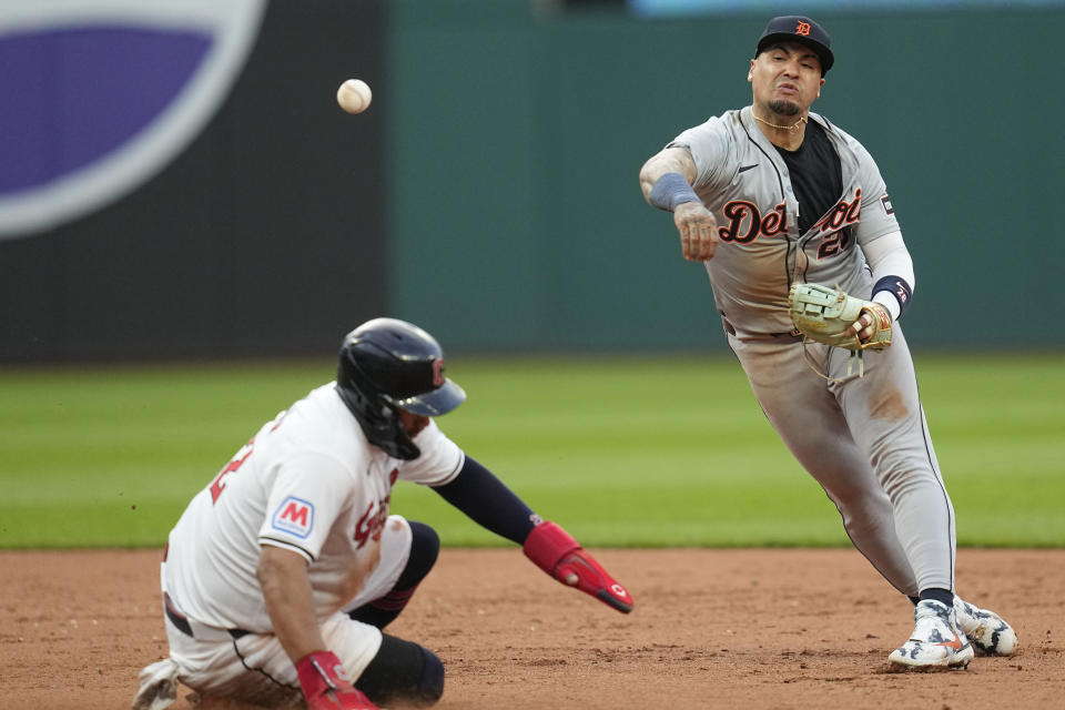 Detroit Tigers shortstop Javier Báez, right, throws to first base after forcing out Cleveland Guardians' Josh Naylor, left, on a double play ball hit into by Will Brennan during the fifth inning of a baseball game Tuesday, May 7, 2024, in Cleveland. (AP Photo/Sue Ogrocki)