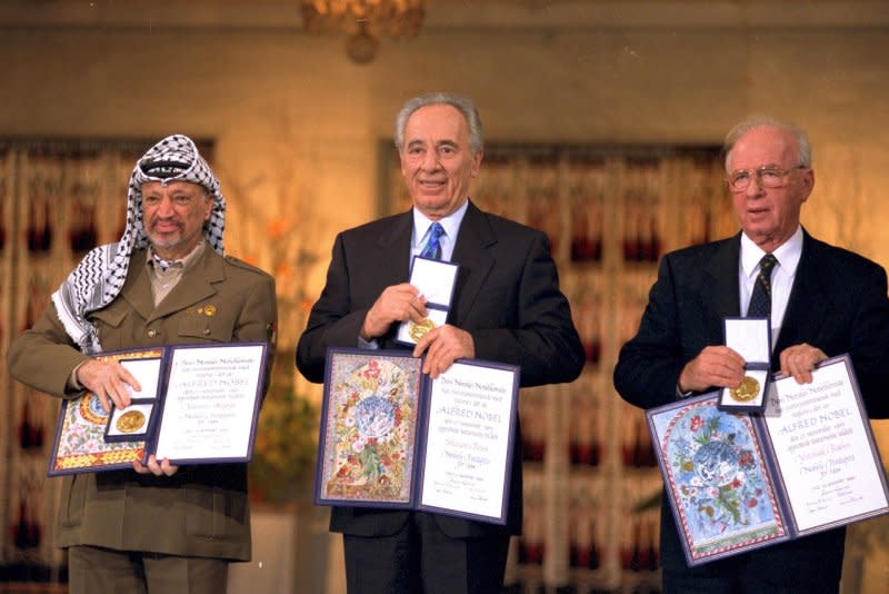 Palestinian leader Yasser Arafat (L), Israeli Foreign Minister Shimon Peres (C) and Prime Minister Yitzhak Rabin hold the Nobel Peace Prize in Oslo, Norway, on December 10, 1994. File Photo by Israeli Government Press Office