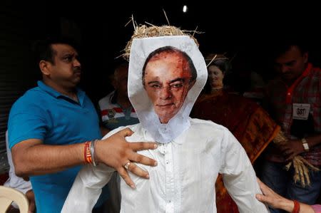 Cloth merchants hold an effigy depicting India's Finance Minister Arun Jaitley before burning it at a protest against the implementation of the Goods and Services Tax (GST) on textiles, in Kolkata, India June 29, 2017. REUTERS/Rupak De Chowdhuri