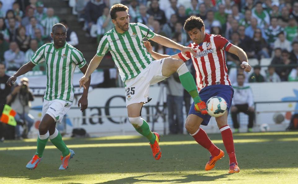 Atletico de Madrid's Diego Costa, right, and Betis' Jordi Figueras , centre, fight for the ball as Betis' Paulao Santos, right, looks on during their La Liga soccer match at the Benito Villamarin stadium, in Seville, Spain on Sunday, March 23, 2014. (AP Photo/Angel Fernandez)