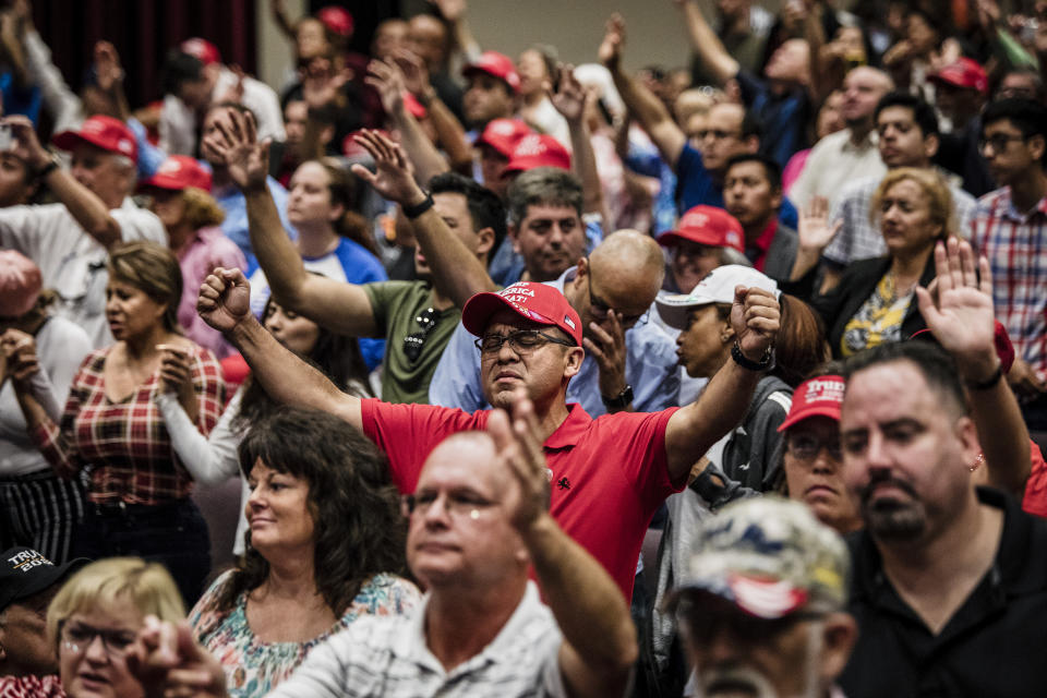 Attendees pray together before President Donald Trump addresses the crowd at the King Jesus International Ministry during a 