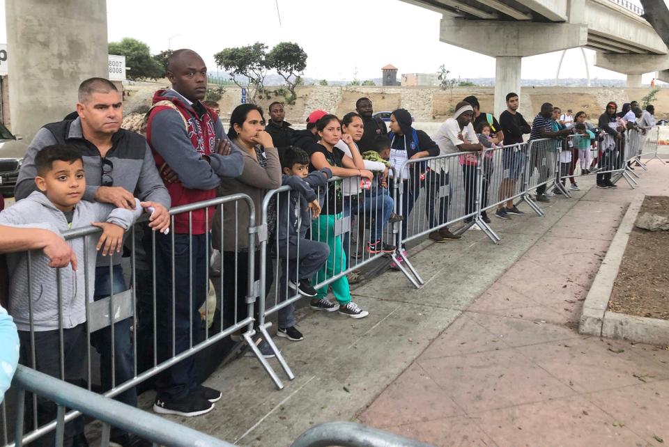 Asylum seekers in Tijuana, Mexico, listen to names being called from a waiting list to claim asylum at a border crossing in San Diego on Sept. 26, 2019.