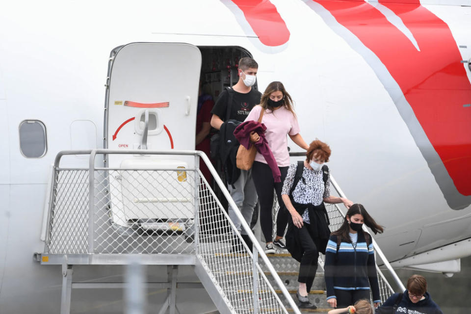 Passengers wearing face masks arrive on a Virgin Australia flight into Ballina Byron Gateway Airport.