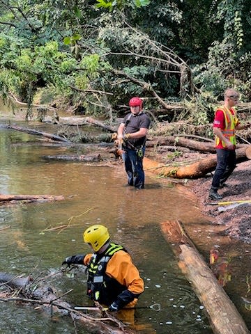 These photos taken July 17-18, 2023 show first responder volunteers digging and checking Houghs Creek by hand on in the debris fields to see which piles could be disassembled by hand.