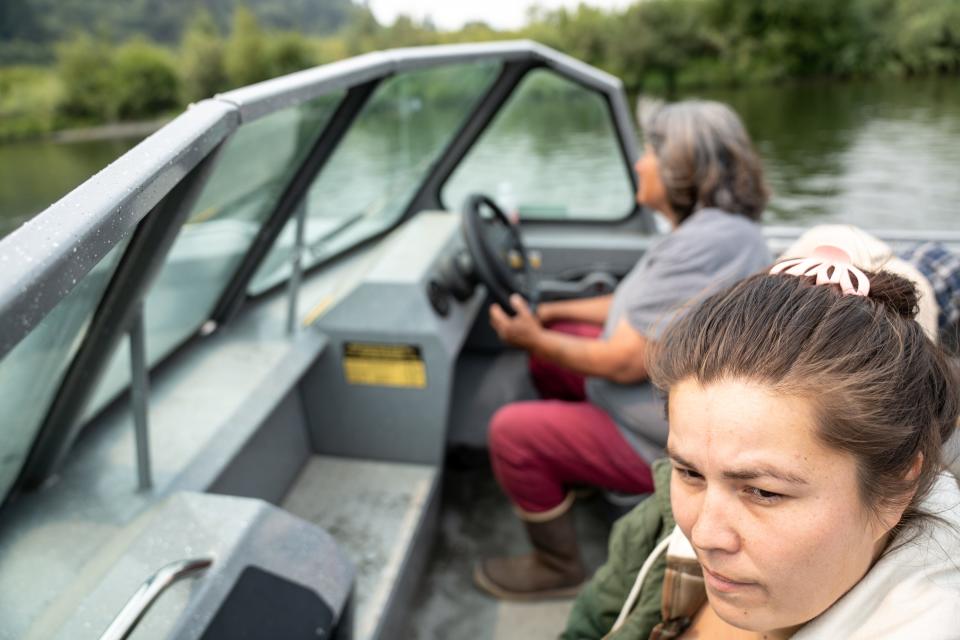 Doreen Ashley (front) and Gloria Mattz (back), fish technicians at the Yurok Fisheries Program, drive a boat along the Klamath River as they survey for dead fish and make their way to scout for fish at Blue Creek near Klamath, California, on Aug. 20, 2023.