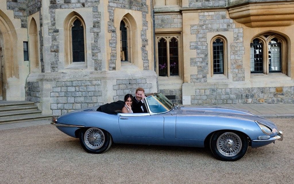 Harry and Meghan in a classic E-Type Jaguar heading off to their wedding reception