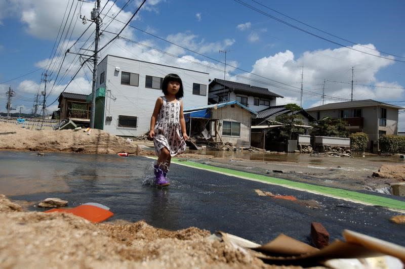 <p>Ein kleines Mädchen läuft über eine überschwemmte Straße im Bezirk Mabi in Kurashiki. Tagelange Regenfälle führten in Japan zu schweren Überschwemmungen und Erdrutschen. Auch mehrere Wohngebiete in der Stadt Kurashiki in der Präfektur Okayama sind betroffen. Rund hundert Tote und Dutzende Vermisste hat die Region bereits zu beklagen. (Bild. REUTERS/Issei Kato) </p>