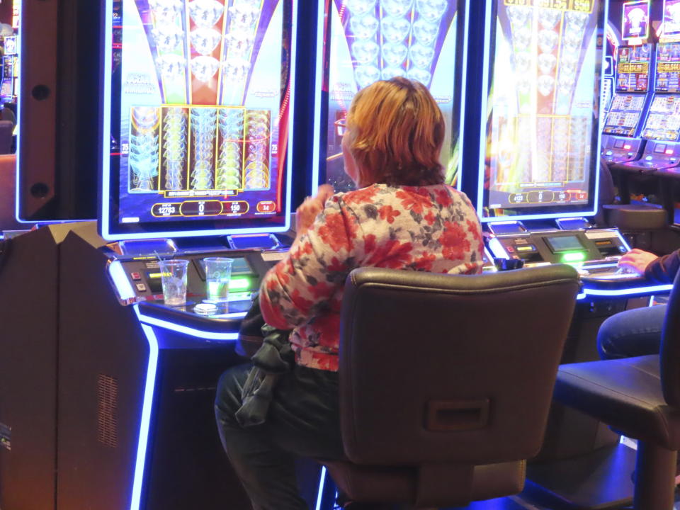 A gambler smokes while playing a slot machine at the Ocean Casino Resort on Wednesday, Nov. 29, 2023, in Atlantic City, N.J. On Thursday, Nov. 30, a bill to ban smoking in Atlantic City's nine casinos was not acted upon following a hearing that was widely expected to start the measure on its way to approval after nearly three years of inaction. (AP Photo/Wayne Parry)