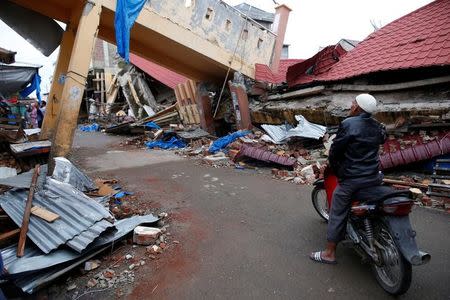 A man looks at the damage to buildings following this week's strong earthquake in Meureudu, Pidie Jaya, Aceh province, Indonesia. REUTERS/Darren Whiteside