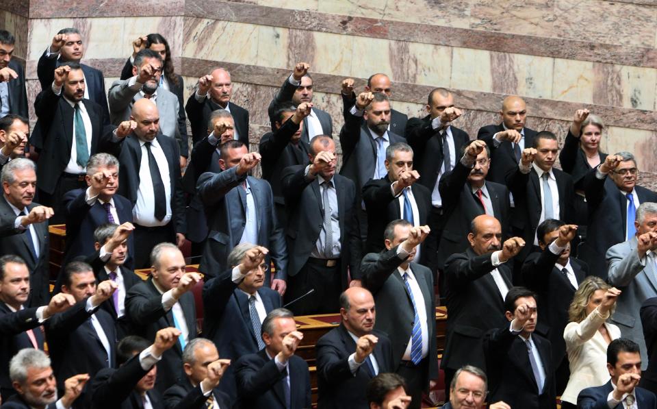 Members of parliament from the extreme right-wing Golden Dawn party, intermingled with other new lawmakers as they are sworn in during a ceremony at the Greek parliament in Athens, Thursday, May 17, 2012. Among the deputies to take their seats for a day are 21 from the Golden Dawn, which rejects the neo-Nazi label. It campaigned on pledges to rid Greece of immigrants and clean up neighborhoods. (AP Photo/Thanassis Stavrakis)