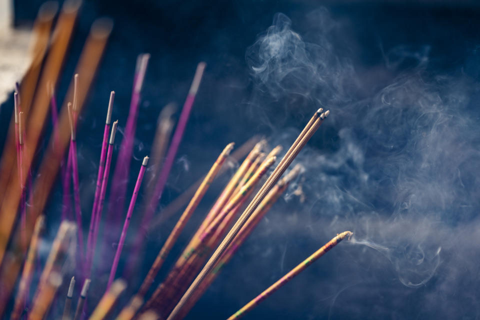 Focus on incense stick and smoke. Symbol Chinese culture.