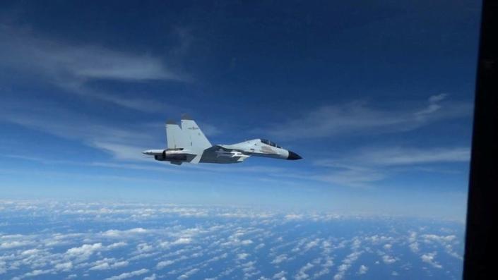 FILE PHOTO: Chinese Navy J-11 fighter jet flies close to a U.S. Air Force RC-135 aircraft over the South China Sea