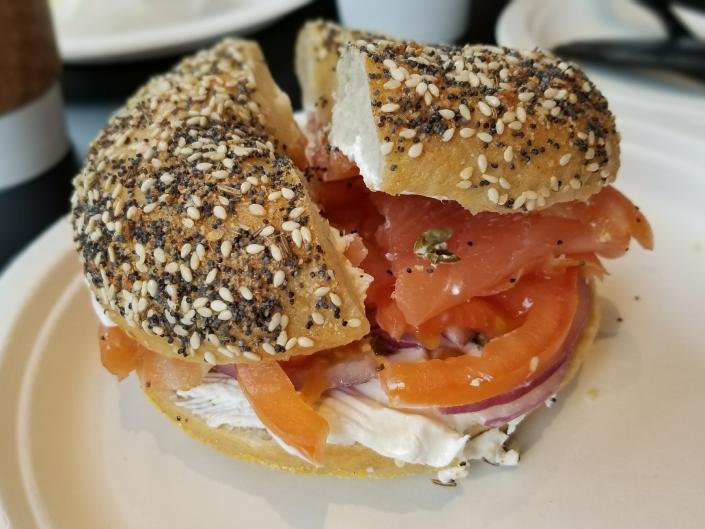 An everything bagel with lox and cream cheese and tomato.