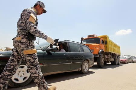 A policeman uses a scanning device to inspect a vehicle at the entrance to Sadr City, northeastern Baghdad April 24, 2010. REUTERS/Mohammed Ameen/Files